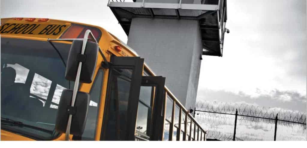 graphic depicting the school-to-prison pipeline. yellow school bus in front of a guard towerpipeline