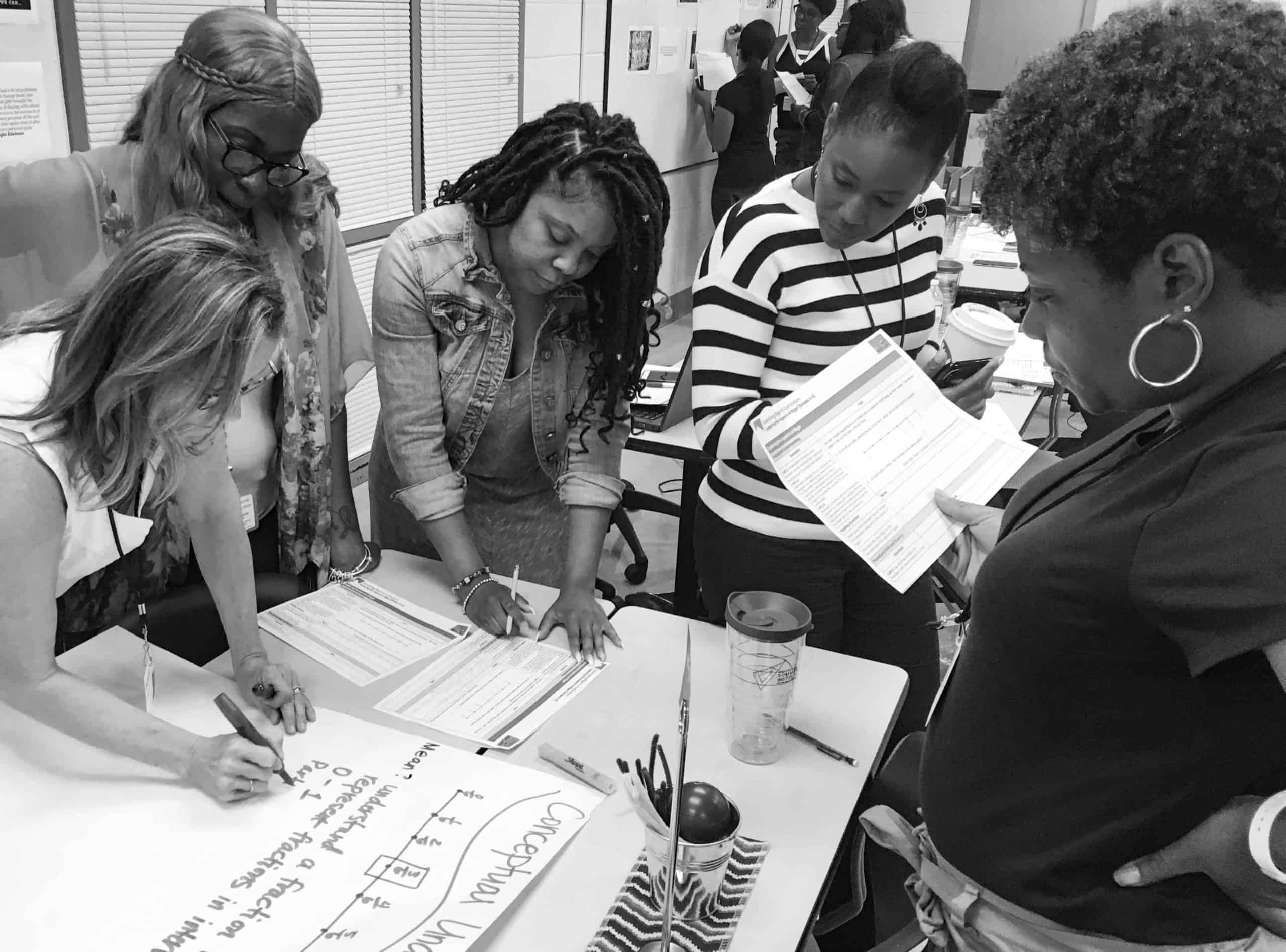 Five leaders work on a math problem during a PLC in Atlanta