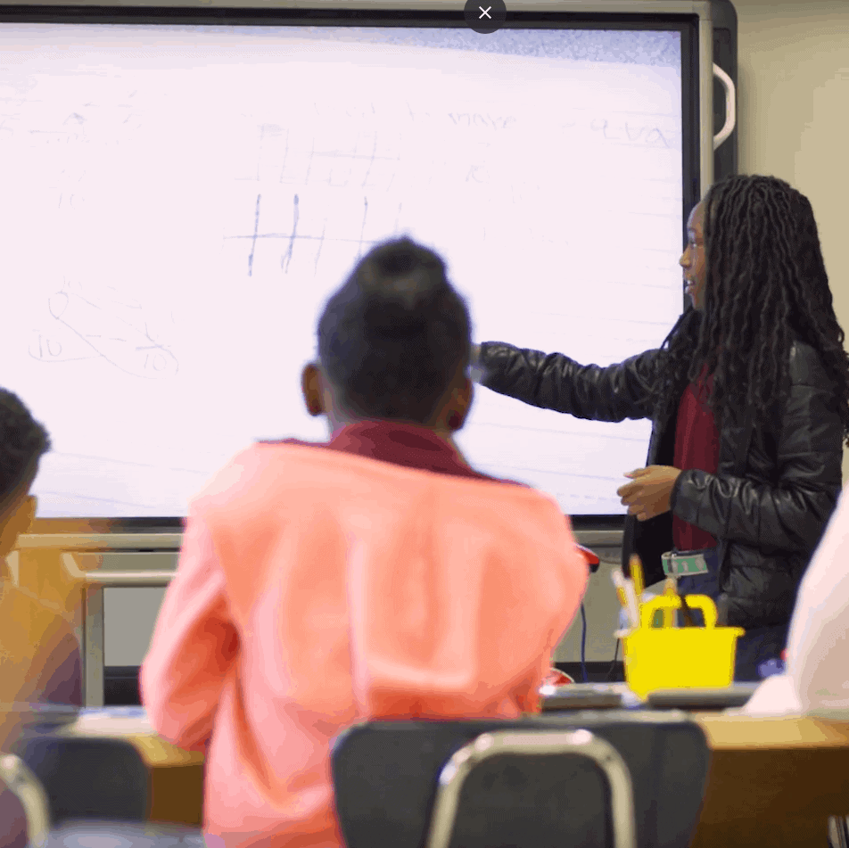 A teacher models a lesson to her class using a smart board