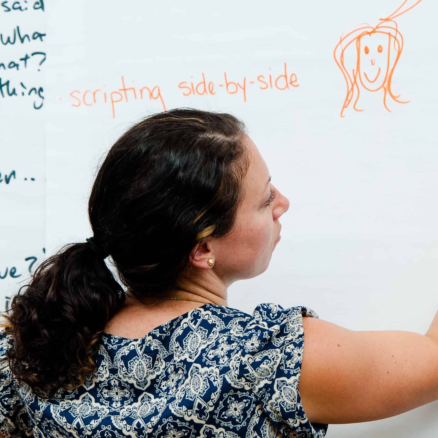 A LEAP participant writes on a whiteboard