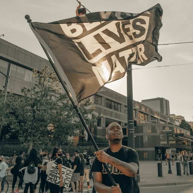 A man waves a Black Lives Matter flag at a protest