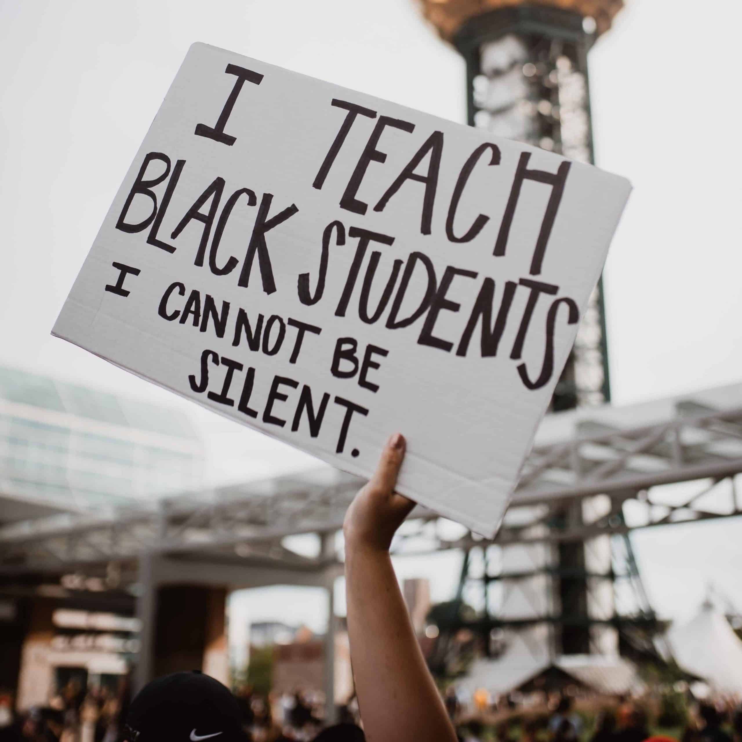 Sign reads "I Teach Black Students I Cannot Be Silent"