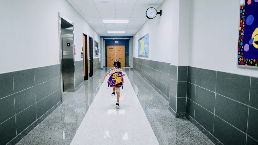 girl walking down a big school hallway