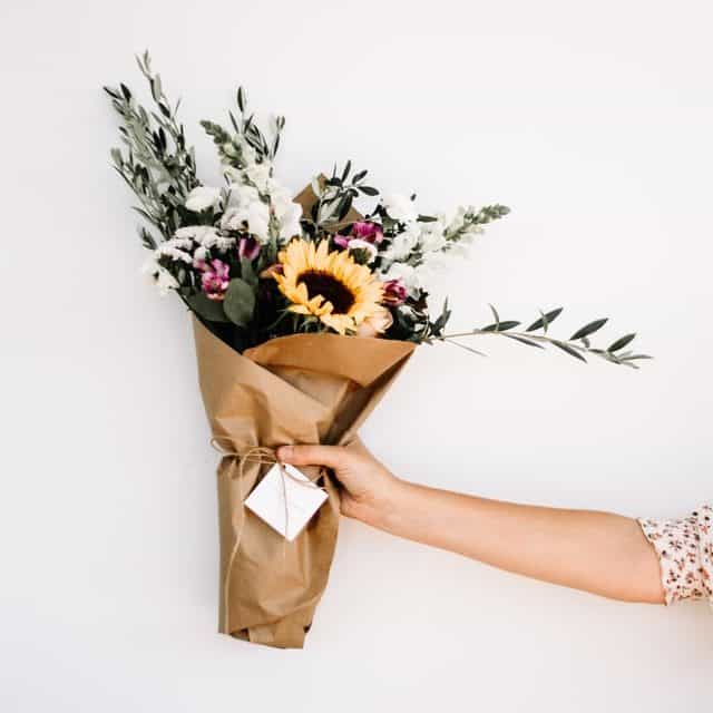 woman's hand holding a bouquet of wildflowers