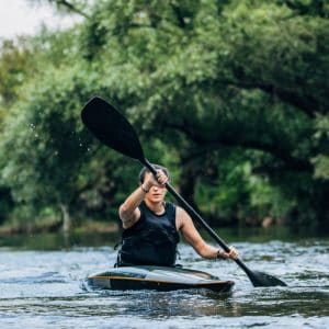 woman rowing kayak in river