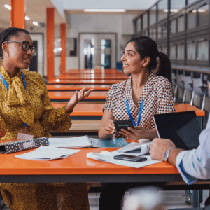 Three educators talk in a school cafeteria