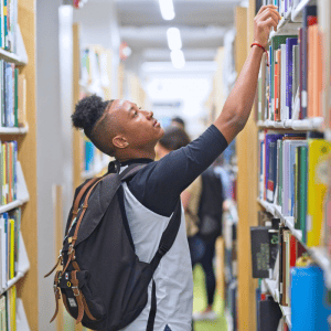 student grabbing a book in the library