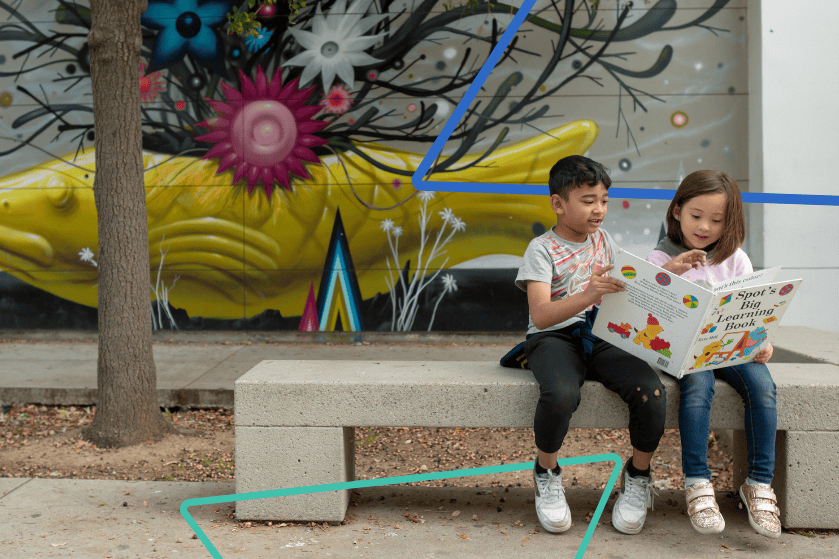 two students reading on a bench